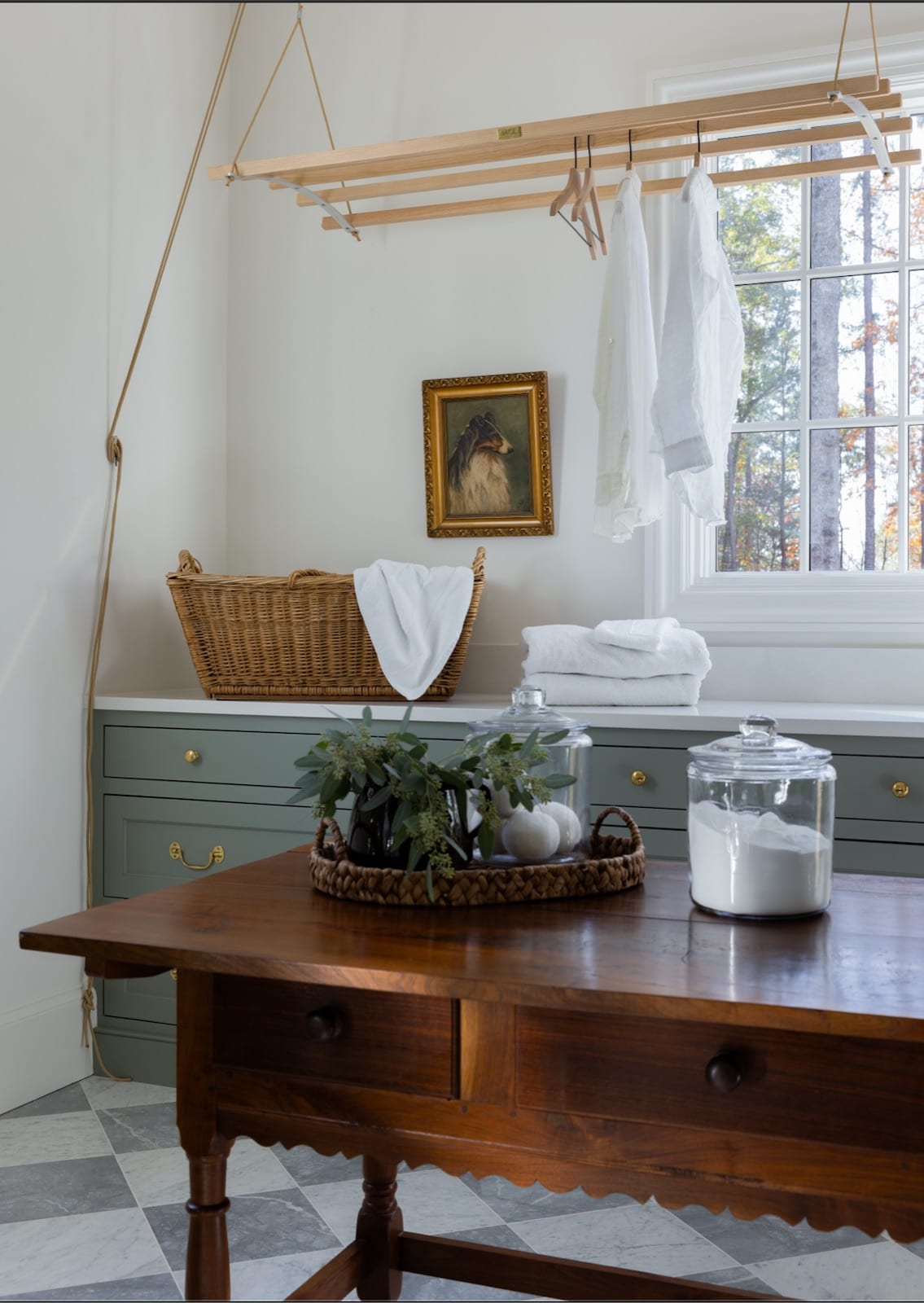 Laundry at Meadowbrook Cottage with sage-green cabinetry, a hanging drying rack and a checkerboard marble floor