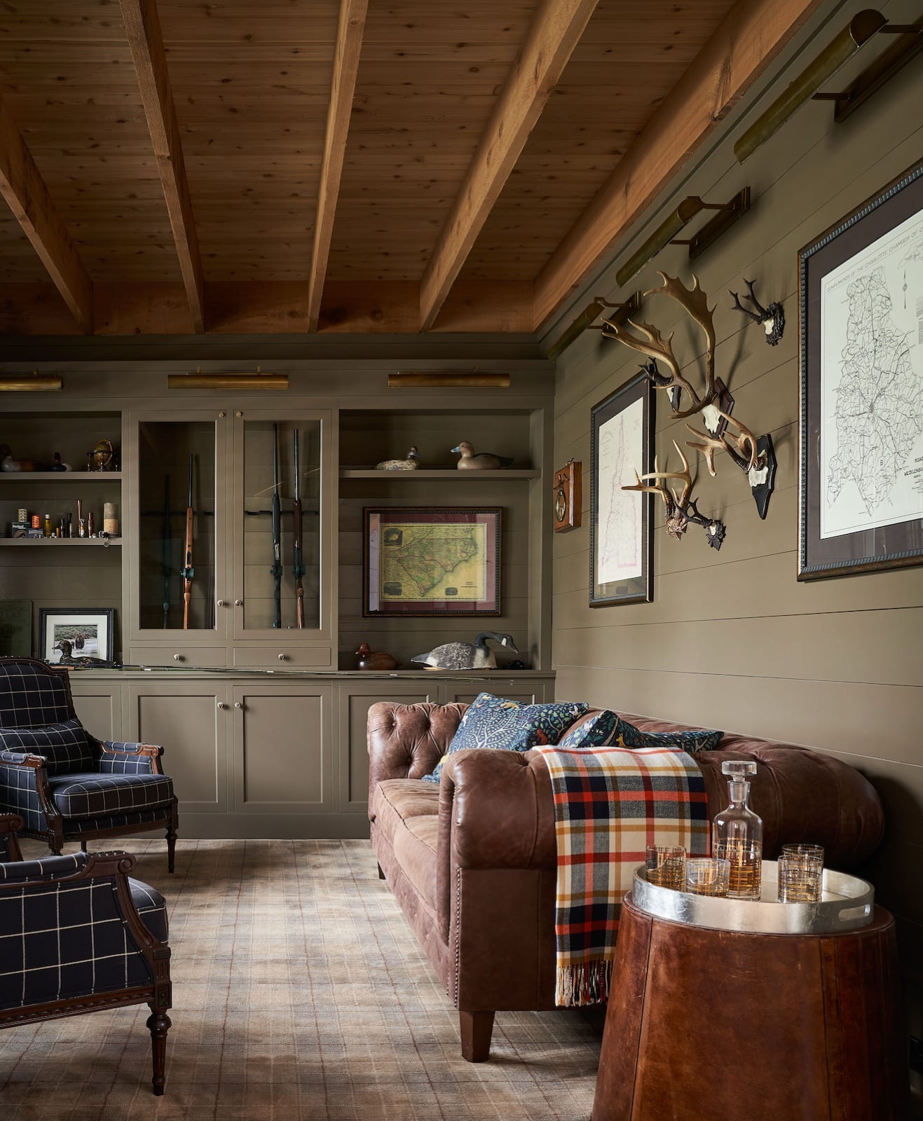 Study at The Potter House with olive-green shiplap walls, a leather Chesterfield sofa and built-in cabinetry