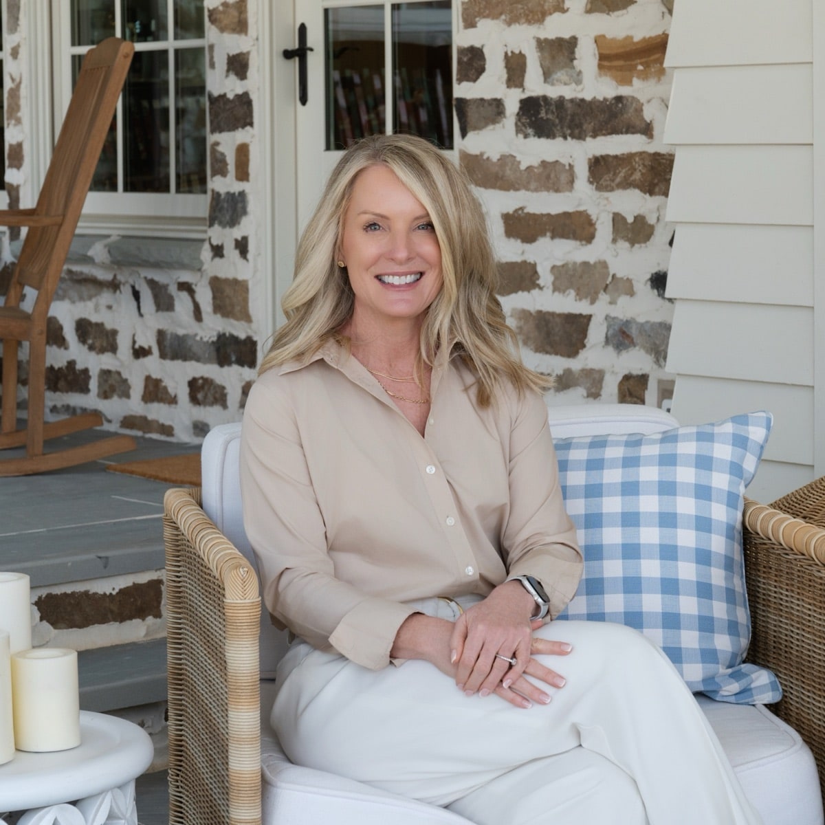 Kim Hedrick, REALTOR® with the Andy Bovender Team at Compass Carolinas, seated on a covered front porch